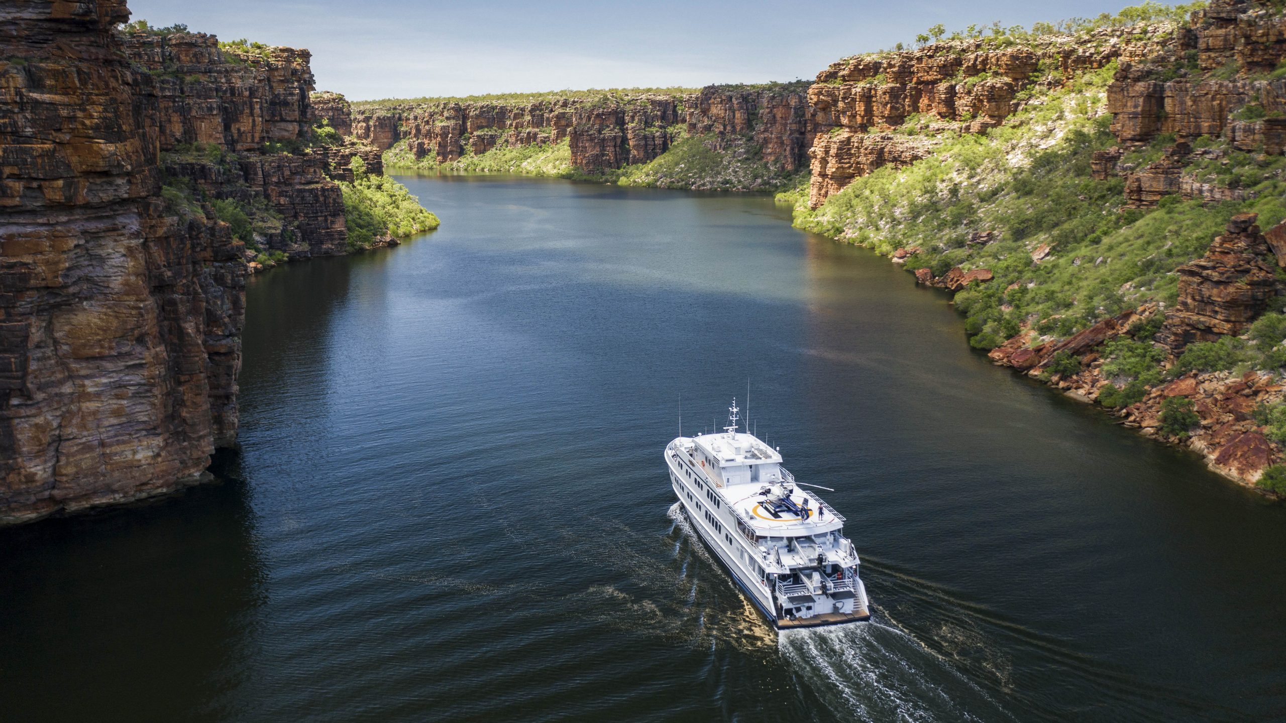 Agent Image Gallery 54 True North Luxury cruise ship navigating through serene Kimberley waters, surrounded by rugged cliffs.